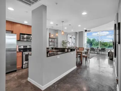 a kitchen and dining room with a table and appliances at Lake Eola Thornton Park Modern 2Bed 2Bath Secure Parking in Orlando