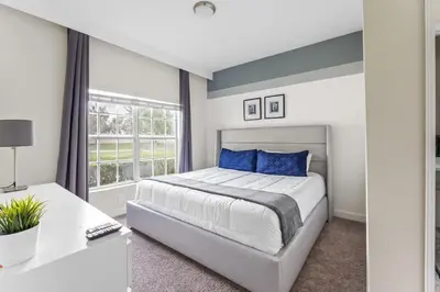 a bedroom with a large bed with blue pillows at 5BR 10 minutes from Disney Springs SL4800 in Kissimmee