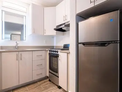 a kitchen with white cabinets and a stainless steel refrigerator at Charming 1BR Home in Orlando minutes to Disney in Kissimmee