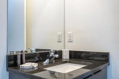 a bathroom with a sink and a mirror at 8761 ZD - Elegant 3BR Villa in The Hub Resort - Comfort, Style, and Luxury for Your Perfect Getaway in Kissimmee