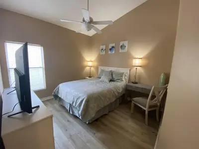 a bedroom with a bed and a desk and a television at 2029 Morning in Orlando