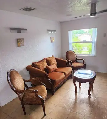 a living room with a couch and two chairs at Ava Lea's Falls in Orlando