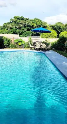 a large blue swimming pool with a blue umbrella at Ava Lea's Falls in Orlando