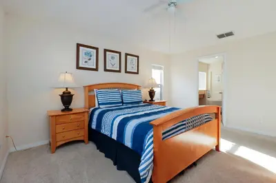 a bedroom with a bed with a blue and white bedspread at Beautiful Emerald Island Resort Retreat with Private Pool and Spa Close to Disney in Kissimmee