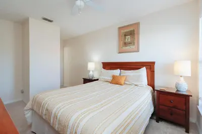 a bedroom with a bed and two night stands with two lamps at Beautiful Emerald Island Resort Retreat with Private Pool and Spa Close to Disney in Kissimmee