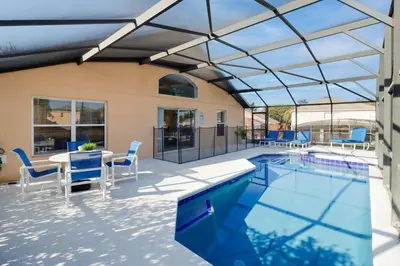 a patio with a pool and a table and chairs at Beautiful Emerald Island Resort Retreat with Private Pool and Spa Close to Disney in Kissimmee