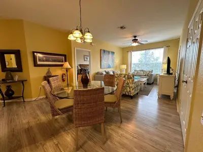 a dining room and living room with a table and chairs at 3Q no Windsor Hills | Perto da Disney + Parque in Orlando