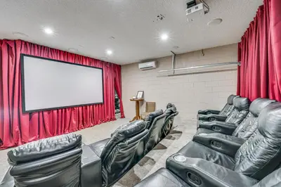 a cinema room with black leather chairs and a screen at 5 Mi to Disney Ideal Family Getaway with Theater! in Kissimmee