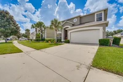 a house with a driveway and a garage at 5 Mi to Disney Ideal Family Getaway with Theater! in Kissimmee