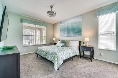 a bedroom with a bed and two windows at 5 Mi to Disney Ideal Family Getaway with Theater! in Kissimmee