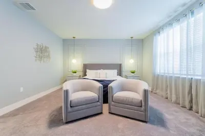 a bedroom with a bed and two chairs at TR17145BD - 3 bedrooms home close to Disney in Orlando