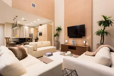 a living room with white furniture and a flat screen tv at Magic Village Yards Trademark Collection by Wyndham in Orlando