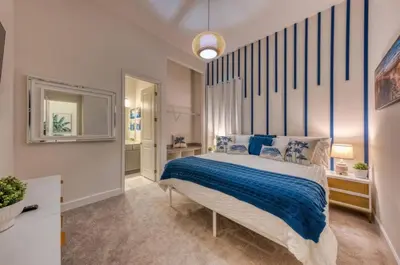 a bedroom with a large bed with blue and white sheets at Experience Luxury in Your 11 En-Suites Mansion in Orlando