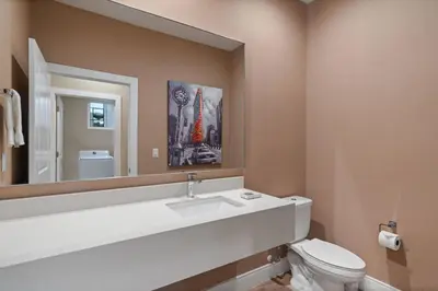 a bathroom with a toilet and a sink and a mirror at Casa Luxuosa 4Q e 4.5 Ba Perto da Disney in Orlando