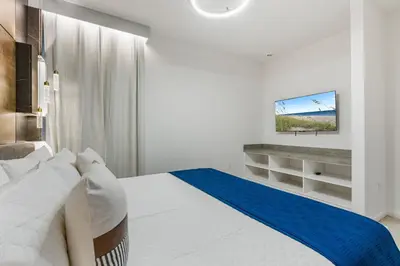 a bedroom with a white bed and a tv on a wall at Brand NEW 10Bedrooms At Paradiso Grande in Orlando