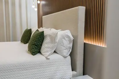 a bed with white pillows and green pillows at Brand NEW 10Bedrooms At Paradiso Grande in Orlando