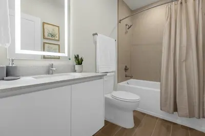 a white bathroom with a toilet and a sink and a tub at Upstay - Modern Family Townhome with Pool in Orlando