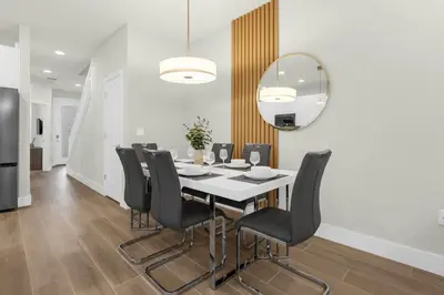 a dining room with a table and black chairs at Upstay - Modern Family Townhome with Pool in Orlando
