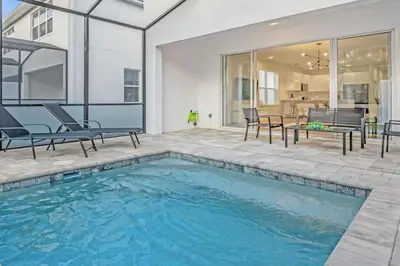 a swimming pool in the backyard of a house at Upstay - Modern Family Townhome with Pool in Orlando