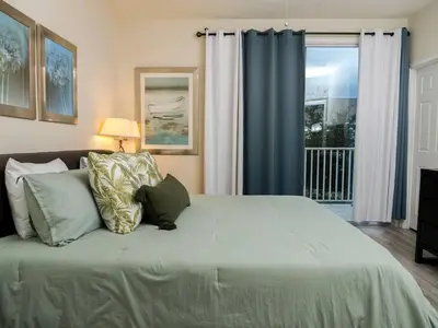 a bedroom with a bed with pillows and a window at Clermont Family Townhouse Pool & Arcade near Disney in Orlando