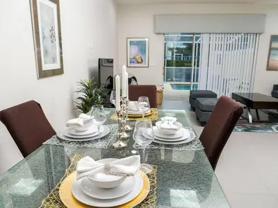 a dining room with a glass table and chairs at Clermont Family Townhouse Pool & Arcade near Disney in Orlando