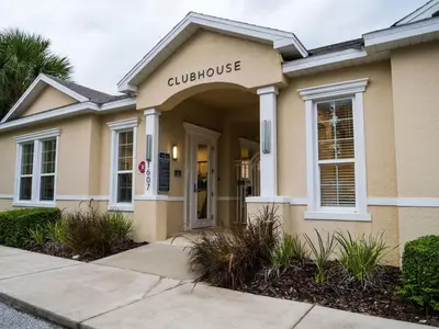a building with a sign for a clubhouse at Clermont Family Townhouse Pool & Arcade near Disney in Orlando