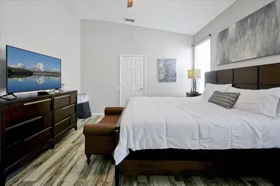a bedroom with a bed and a dresser with a television at Making Memories Resort -Windsor Palms Villa in Kissimmee