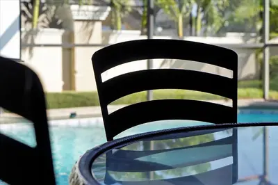 a black chair sitting next to a swimming pool at Making Memories Resort -Windsor Palms Villa in Kissimmee