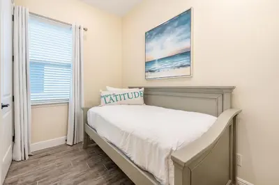 a small bedroom with a bed and a window at Blue Cottage Near Disney With Margaritaville Resort & Island H2O Access - 8067Kd in Orlando