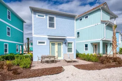a colorful house with a patio and a table at Blue Cottage Near Disney With Margaritaville Resort & Island H2O Access - 8067Kd in Orlando
