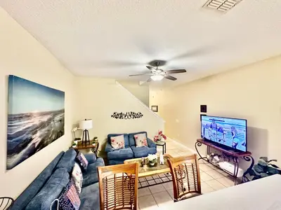 a living room with a couch and a flat screen tv at Grand Luxury 3BR Townhouse Near Disney Parks in Kissimmee