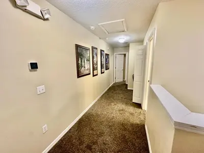 a hallway of a home with paintings on the walls at Grand Luxury 3BR Townhouse Near Disney Parks in Kissimmee