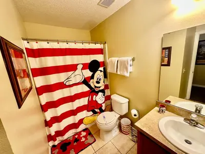 a bathroom with a shower curtain with mickey mouse on it at Grand Luxury 3BR Townhouse Near Disney Parks in Kissimmee