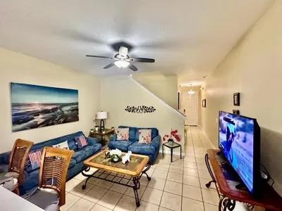 a living room with a couch and a tv at Grand Luxury 3BR Townhouse Near Disney Parks in Kissimmee