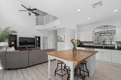 a kitchen and living room with a table and a couch at Tropical 7BR Heated Pool Pet Friendly Disney in Kissimmee