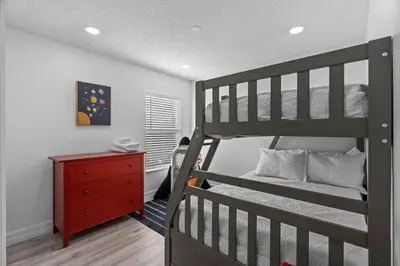a bedroom with a bunk bed and a red dresser at Tropical 7BR Heated Pool Pet Friendly Disney in Kissimmee