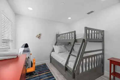 a bedroom with two bunk beds and a desk at Tropical 7BR Heated Pool Pet Friendly Disney in Kissimmee