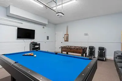 a room with a pool table and a flat screen tv at Tropical 7BR Heated Pool Pet Friendly Disney in Kissimmee