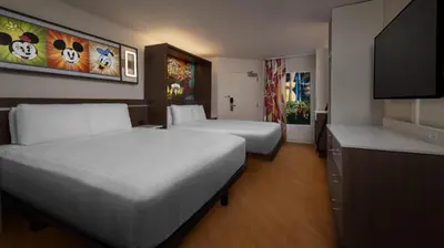 a hotel room with two beds and a flat screen tv at Disney's All-Star Music Resort in Orlando