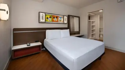 a bedroom with a large white bed in a room at Disney's All-Star Music Resort in Orlando