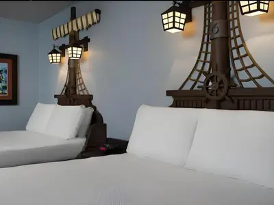 a bedroom with a bed with two towers on the wall at Disney's Caribbean Beach Resort in Orlando