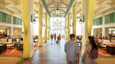 a man and a woman walking through a lobby at Disney's Caribbean Beach Resort in Orlando