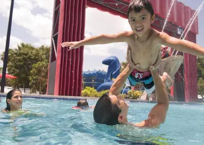a young boy jumping in a swimming pool at Disney's All-Star Movies Resort in Orlando