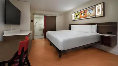 a bedroom with a white bed and a flat screen tv at Disney's All-Star Movies Resort in Orlando