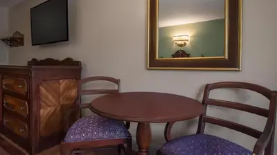a room with a table and two chairs and a mirror at Disney's Port Orleans Resort - French Quarter in Orlando
