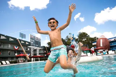 two young boys jumping in a swimming pool at Disney's All-Star Sports Resort in Orlando