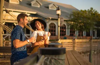 a man and a woman standing next to a picnic table at Disney's Port Orleans Resort - Riverside in Orlando