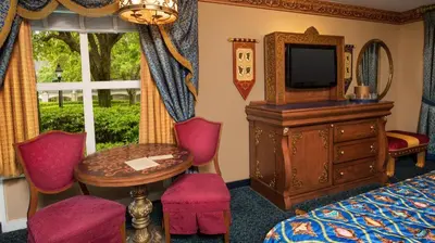 a hotel room with a bed and a television and a table at Disney's Port Orleans Resort - Riverside in Orlando