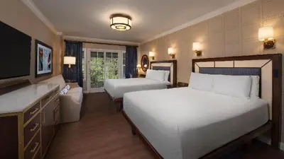 a hotel room with two beds and a television at Disney's Yacht Club Resort in Orlando