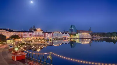a city at night with lights on the water at Disney's Boardwalk Inn in Orlando
